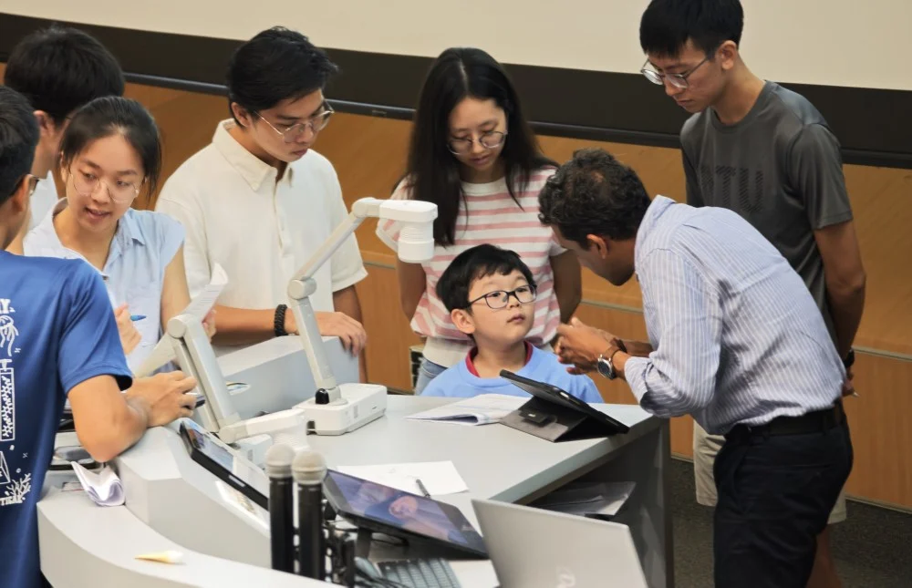 Budak genius IQ 154 Theodore Kwan, 7 tahun, sedang berbincang dengan pensyarah ketika menghadiri kuliah kimia di Universiti Teknologi Nanyang, Singapura.