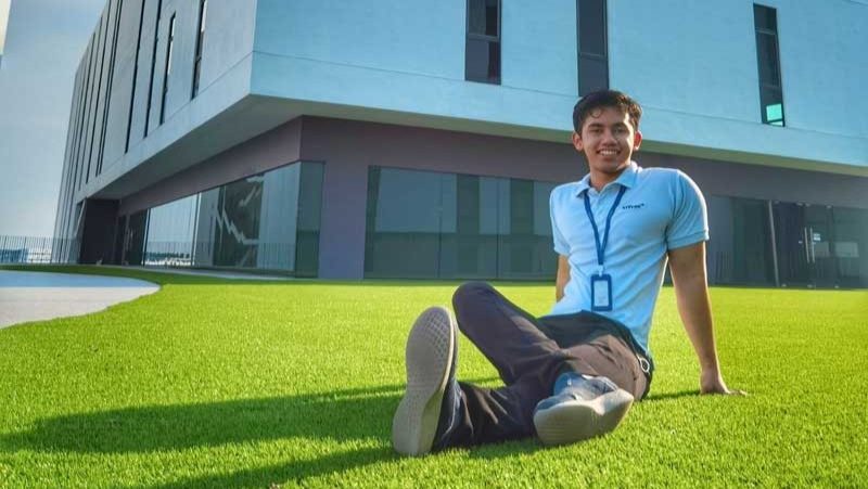 Muhammad Fathy Rashad sitting in front of Universiti Teknologi Petronas (UTP) building, the youngest student who became an AI company founder