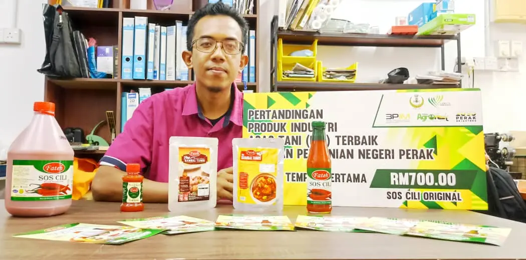 Muhammad Fitri Jamil usahawan produk berasaskan cili bersama pelbagai produk sos cili dan pes sambal jenama Fateh di premis perniagaannya di Perak.