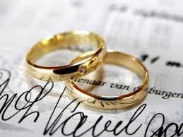 Two elegant gold wedding rings resting on a handwritten document, symbolizing love, commitment, and the sacred bond of marriage
