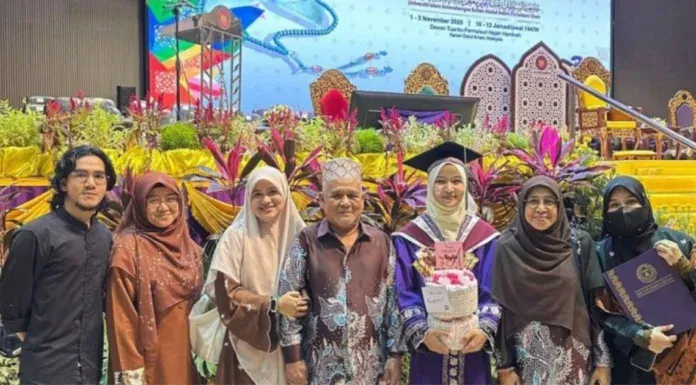Sebuah keluarga bergambar bersama graduan wanita di majlis konvokesyen universiti.