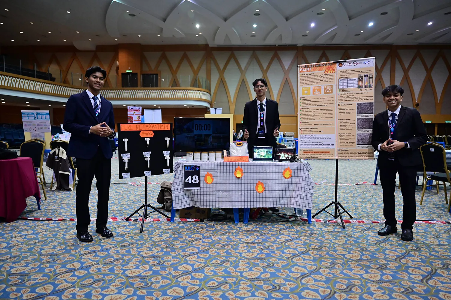 Tiga pelajar Universiti Teknologi Malaysia (UTM) mempamerkan projek Fire-Retardant Paint pada pertandingan International Undergraduate Innovation Competition (IUIC’25) di UTHM, Batu Pahat.
