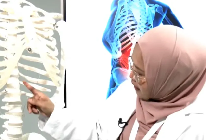 Seorang penyelidik wanita menunjukkan model rangka manusia ketika menerangkan rawatan berkaitan tulang belakang