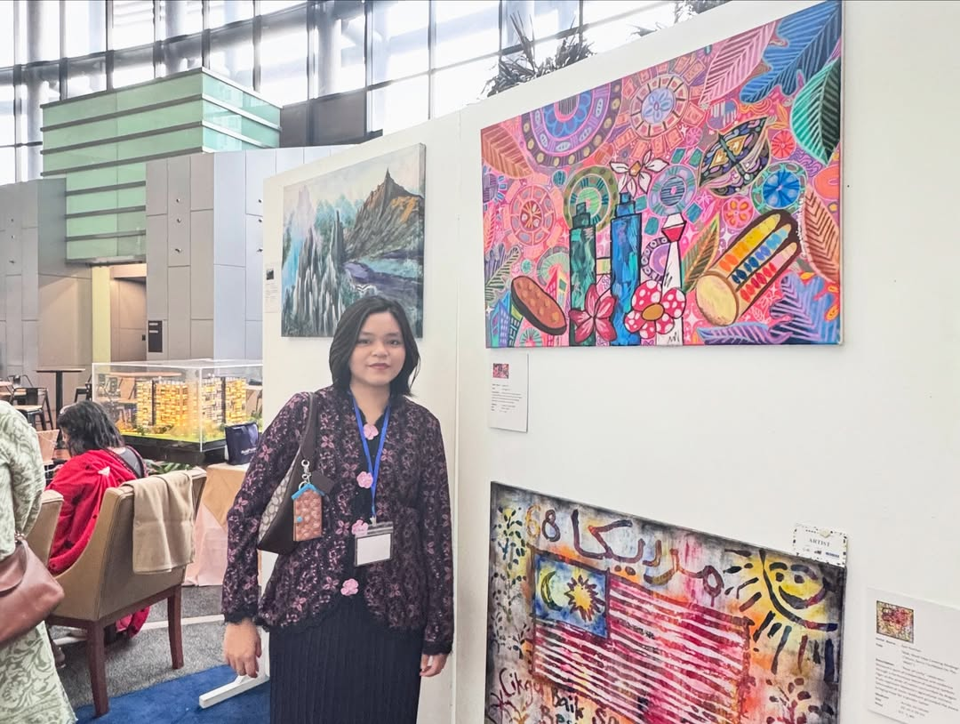 Danya Adriana Feri Pito Manda bersama karya seni abstrak bertemakan warisan Malaysia dalam pameran seni