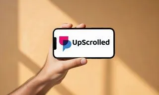 Telefon pintar memaparkan logo UpScrolled sebagai platform media sosial alternatif tanpa penapisan