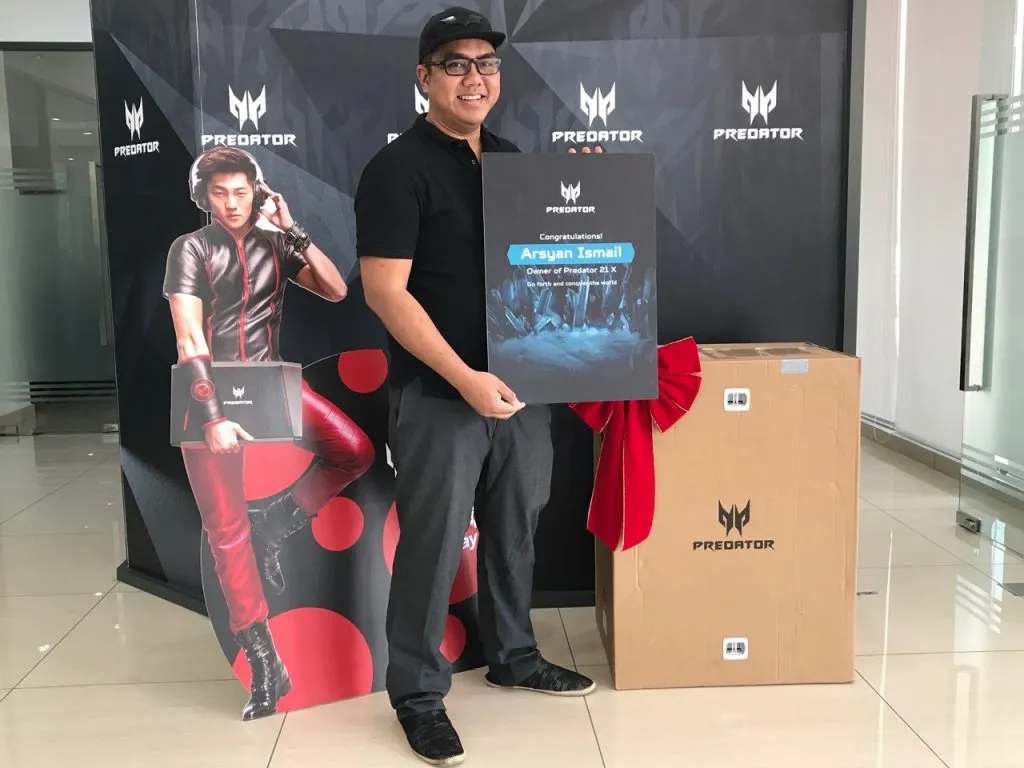 Arsyan Ismail bergambar bersama komputer riba Acer Predator 21 X dalam majlis penyerahan rasmi