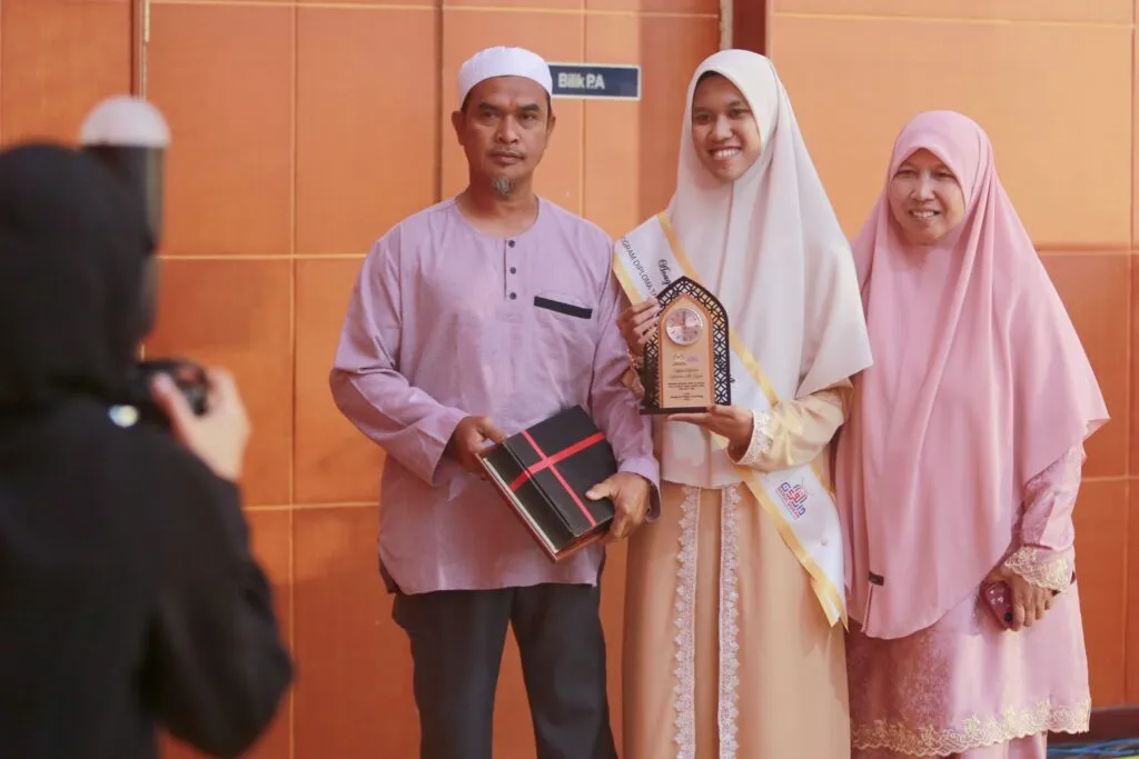 Ainin bergambar bersama trofi dan hadiah selepas menerima anugerah