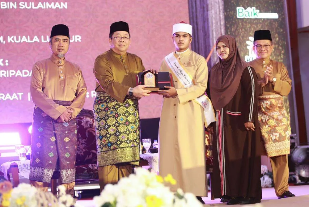 Muhammad Ariffin Ibrahim Ali menerima Anugerah Pelajar Cemerlang Darul Quran di majlis rasmi