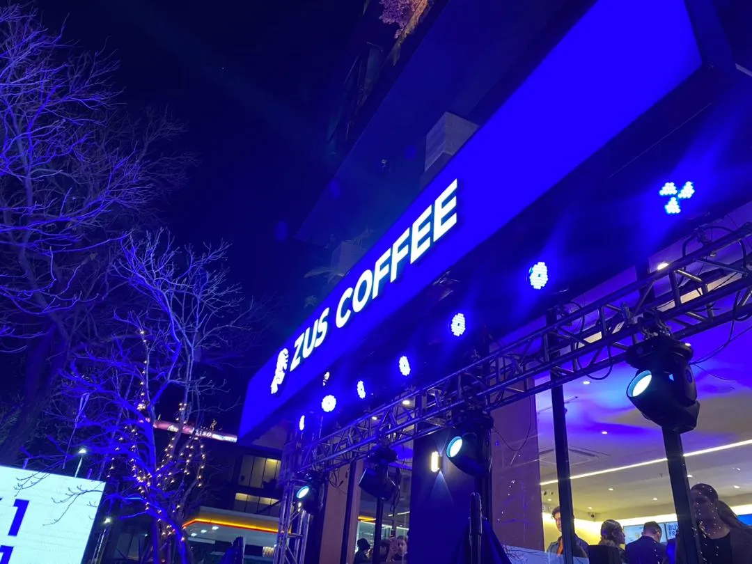Luar ZUS Coffee di Islamabad pada waktu malam dengan papan tanda bercahaya