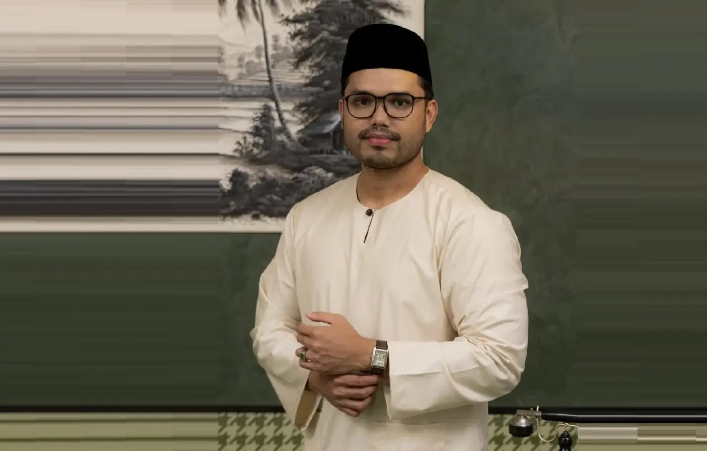 Khairul Aming memakai baju Melayu lengkap dengan kopiah dan cermin mata