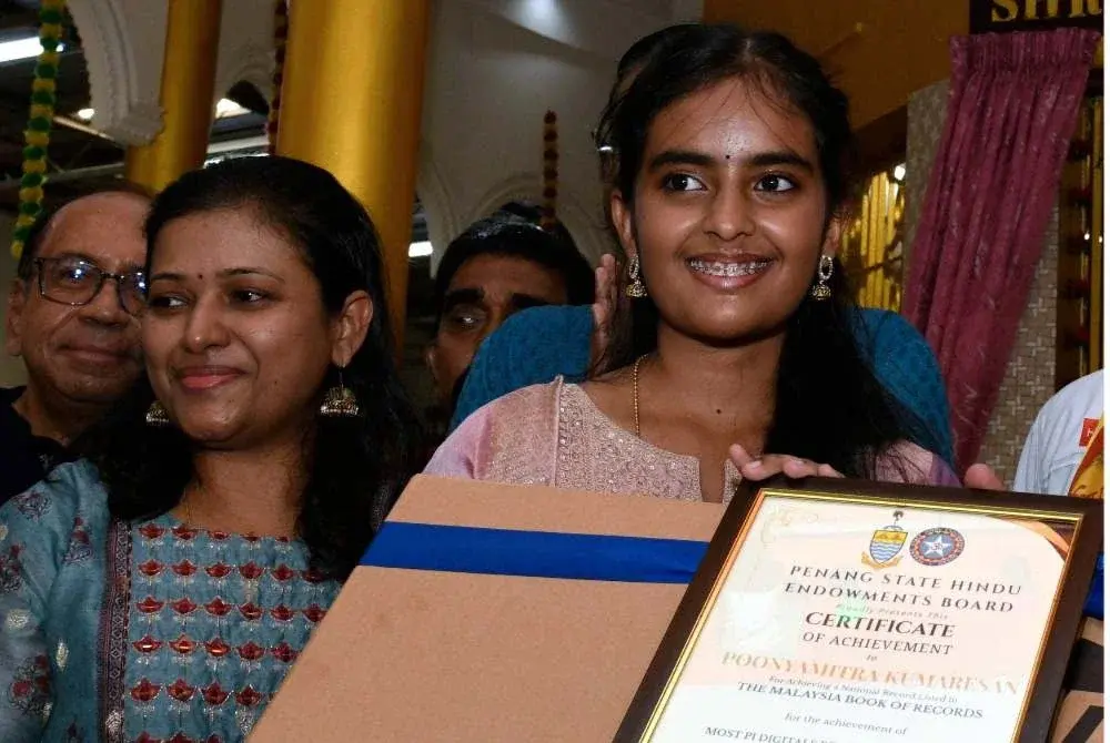 K Poonyamitra menerima sijil pengiktirafan selepas mencipta Rekod Pi Malaysia dengan menghafal 300 digit nombor Pi