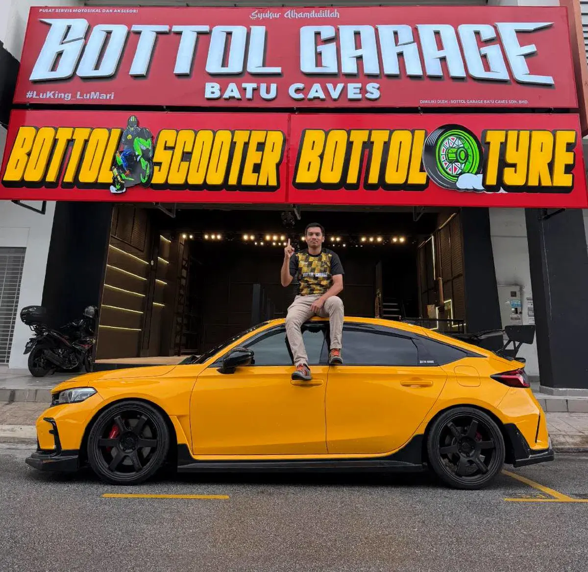 Bottol Garage Batu Caves dengan kereta kuning modifikasi dan pemilik duduk di atas kereta