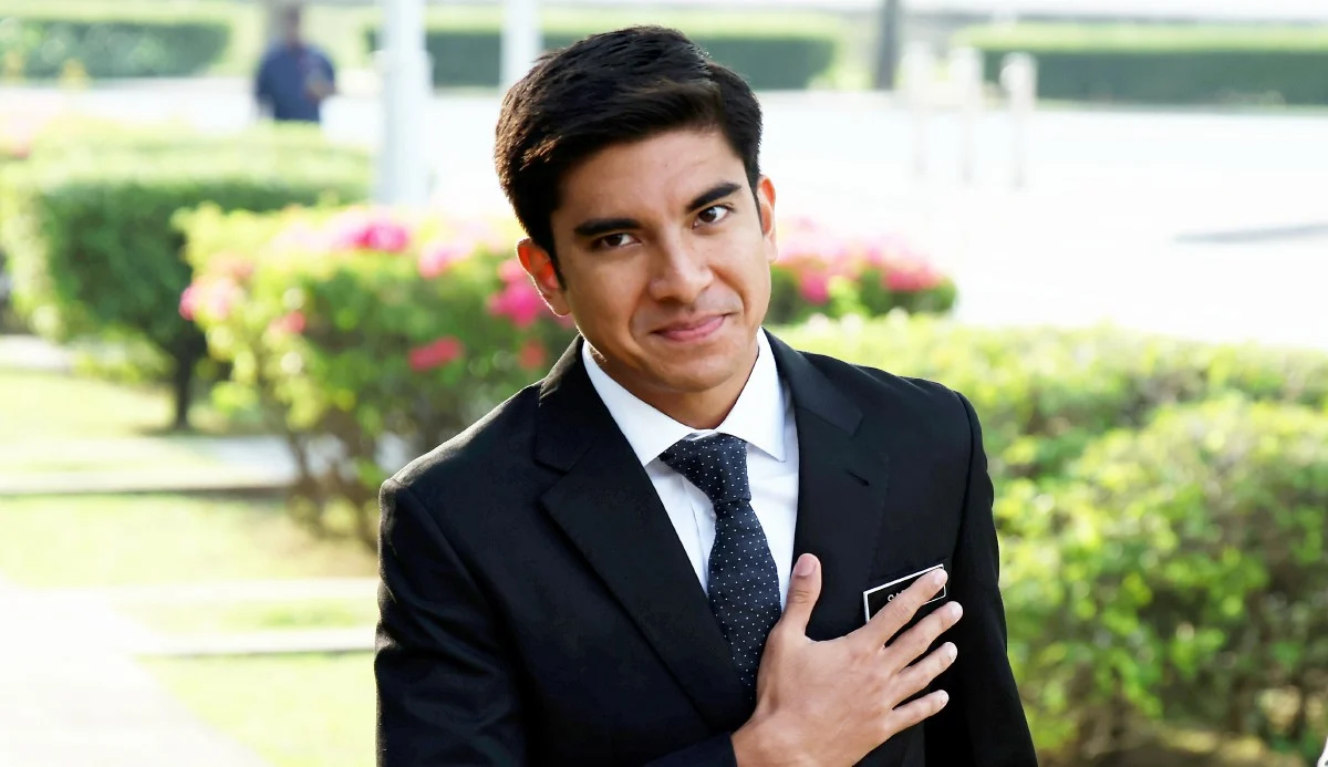 Syed Saddiq alumni MTD dan pendebat terbaik Asia memakai sut hitam di luar bangunan