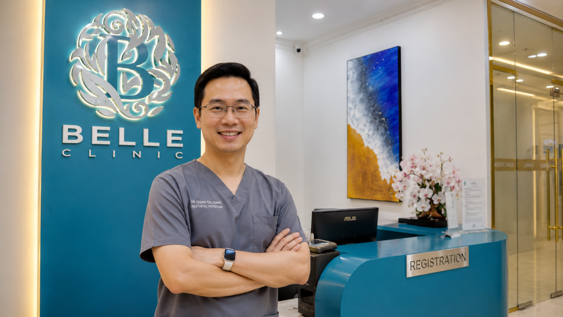 Dr. Chiam Tee Kiang bergambar di ruang penerimaan Belle Clinic dengan latar dalaman moden dan identiti klinik estetik